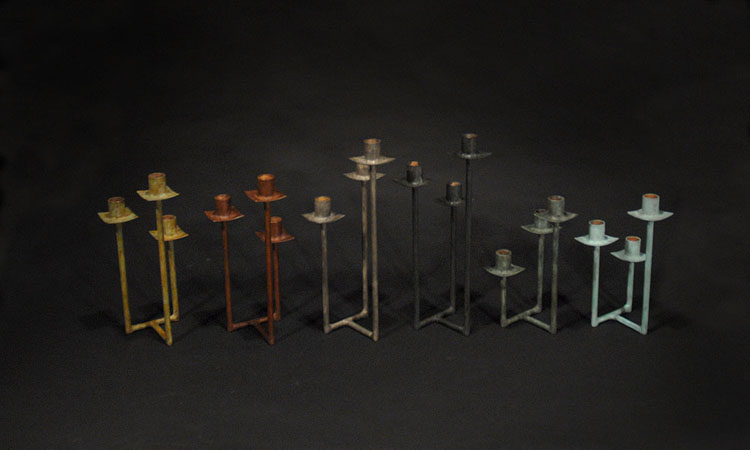six colors of patinaed brass rod triple candelabra